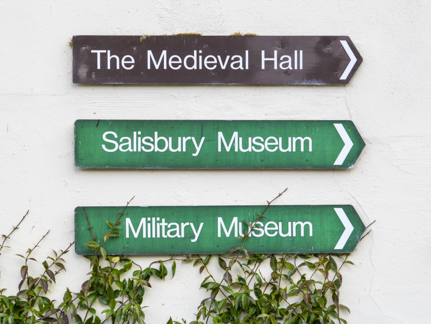 Wall signs directing to The Medieval Hall, Salisbury Museum, and Military Museum.