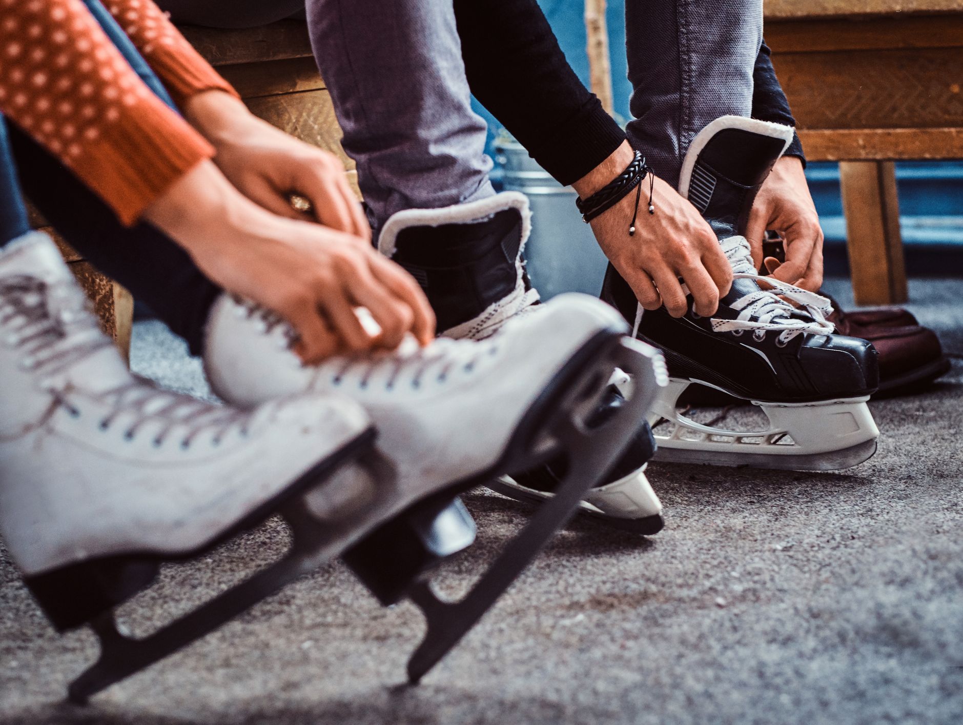 People lacing up ice skates in preparation for a festive skating session, capturing the cozy charm of Christmas in Wiltshire.