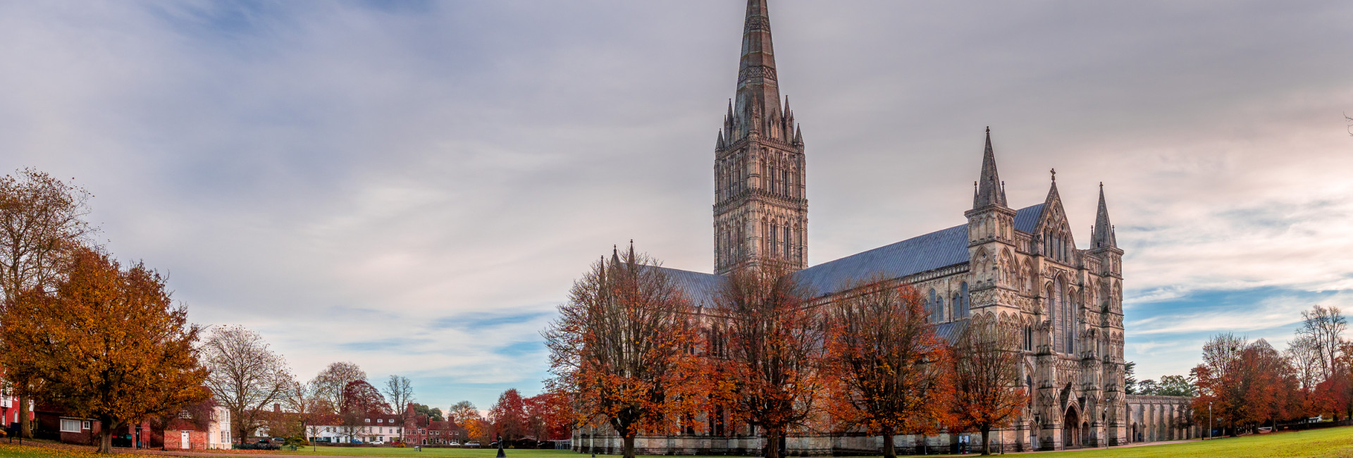 Historic Salisbury Cathedral and its spire, set against a backdrop of autumn colors.